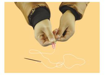 Fix a paper clip to one end of the thread